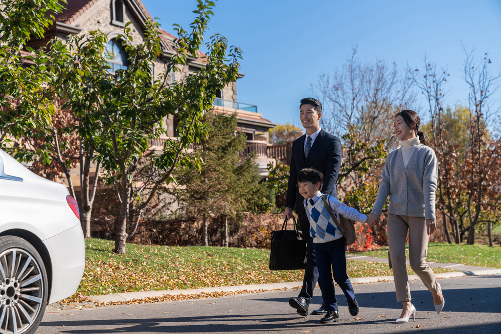 年轻夫妻送孩子去上学图片