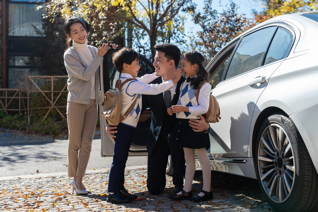 年轻夫妻接孩子放学图片