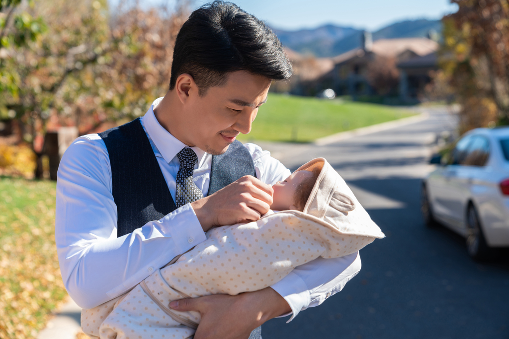 年轻商务男士抱着婴儿