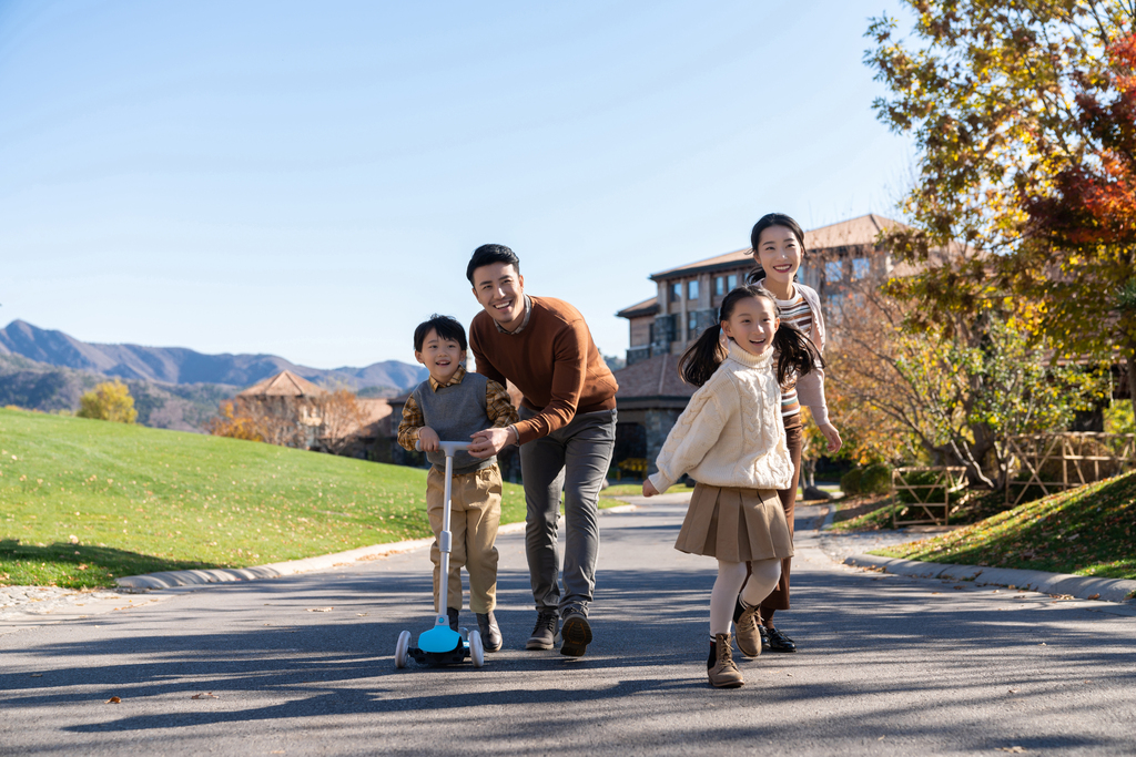 年轻夫妻带着孩子们在玩滑板车图片