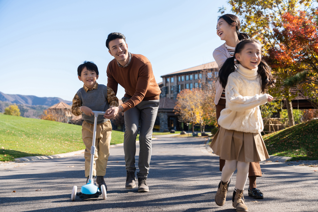 年轻夫妻带着孩子们在玩滑板车图片