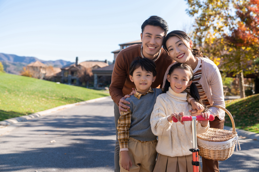 年轻夫妻带着孩子们在玩滑板车图片