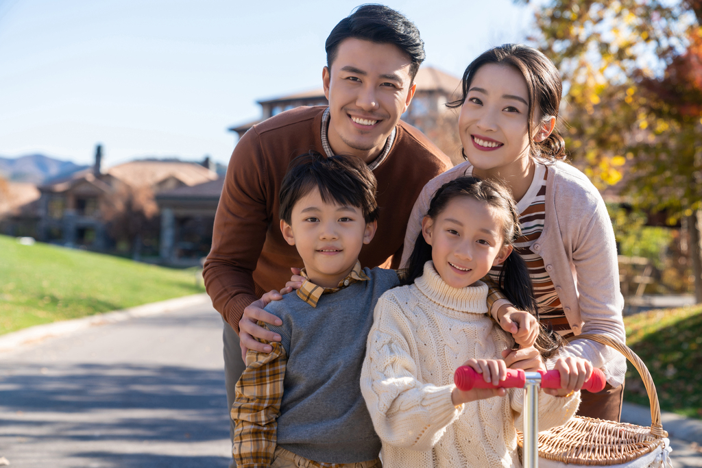 年轻夫妻带着孩子们在玩滑板车