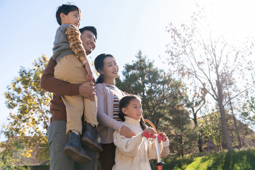 年轻夫妻带着孩子们在玩滑板车图片