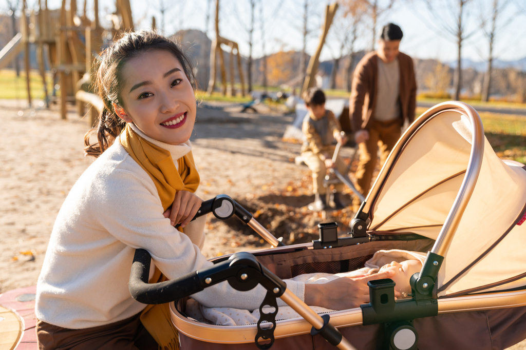 年轻家庭推着婴儿车散步图片