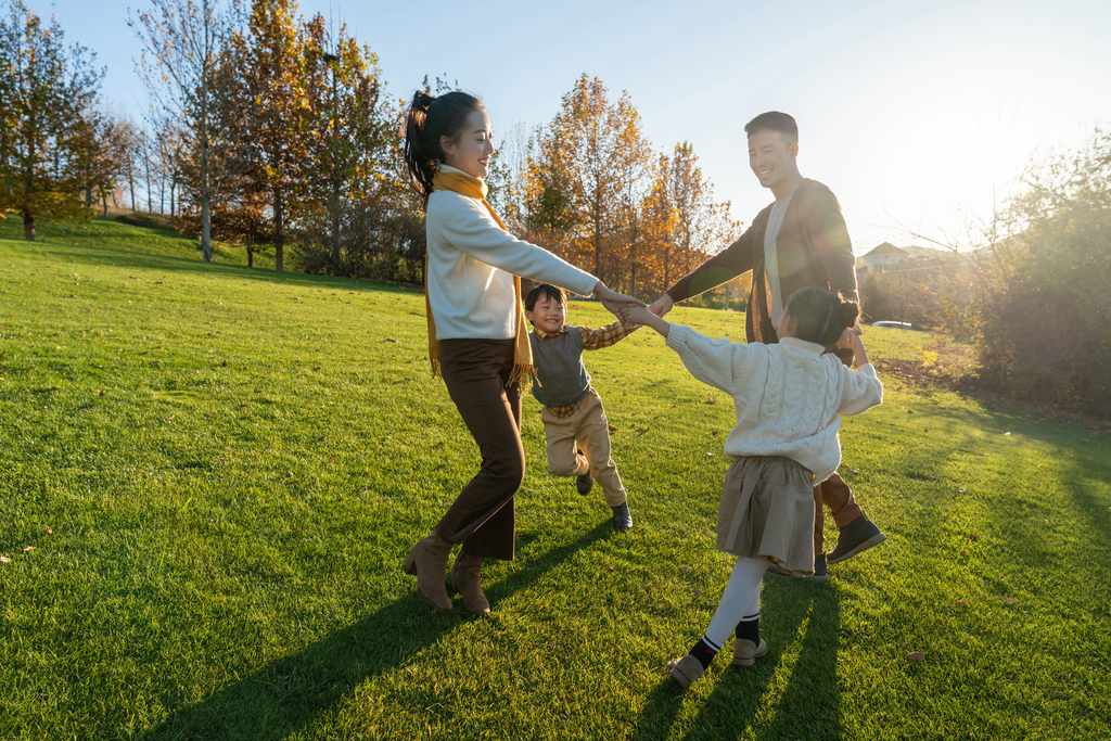 年轻夫妻带着孩子在公园玩耍图片