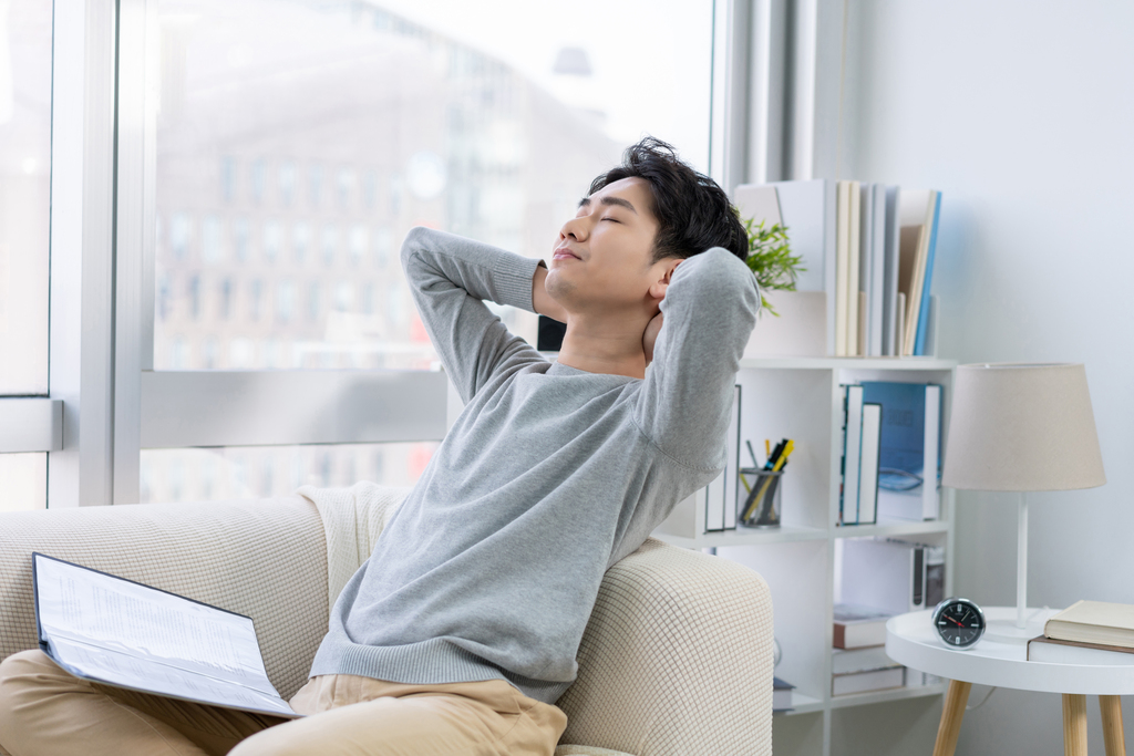 年轻男子在沙发上看文件图片