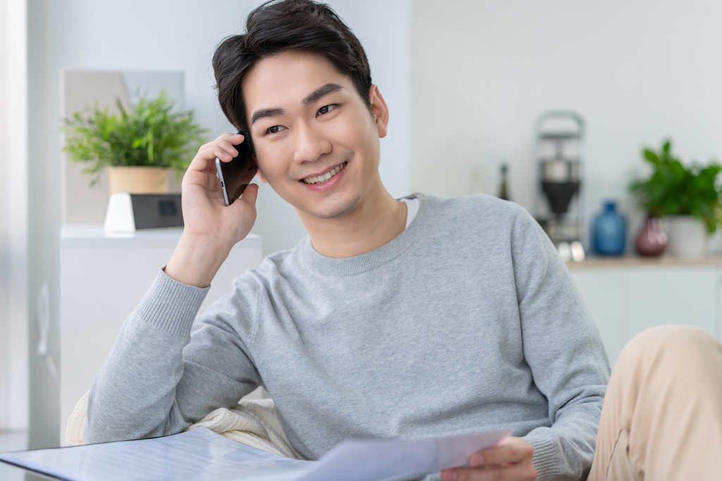 年轻男子坐在沙发上打电话