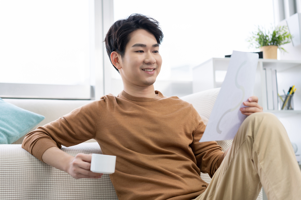 年轻男子在家看文件图片