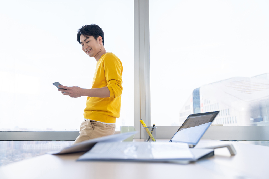 年轻男子在办公室打电话图片