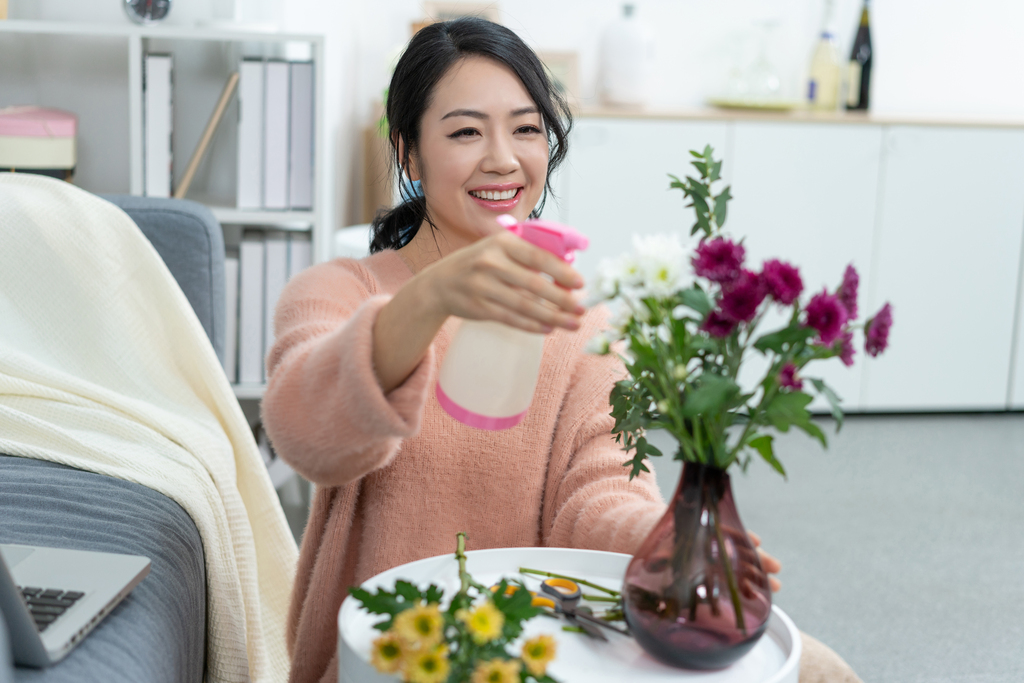 年轻女子在家浇花图片