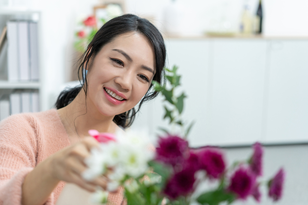 年轻女子在家浇花图片