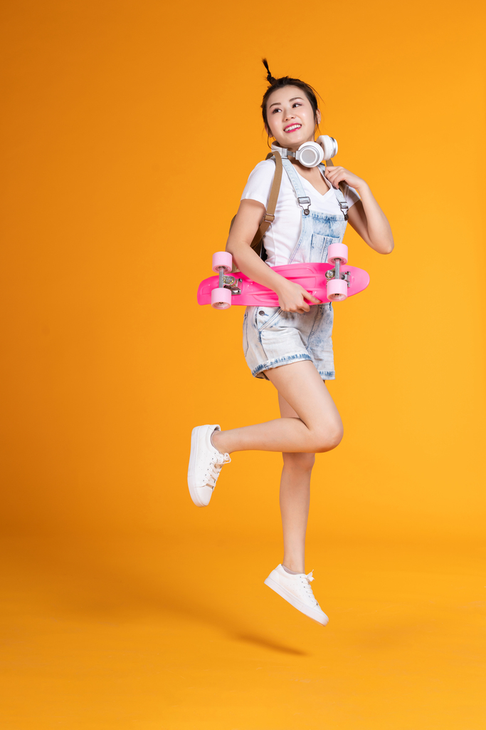 棚拍拿着滑板的年轻女子