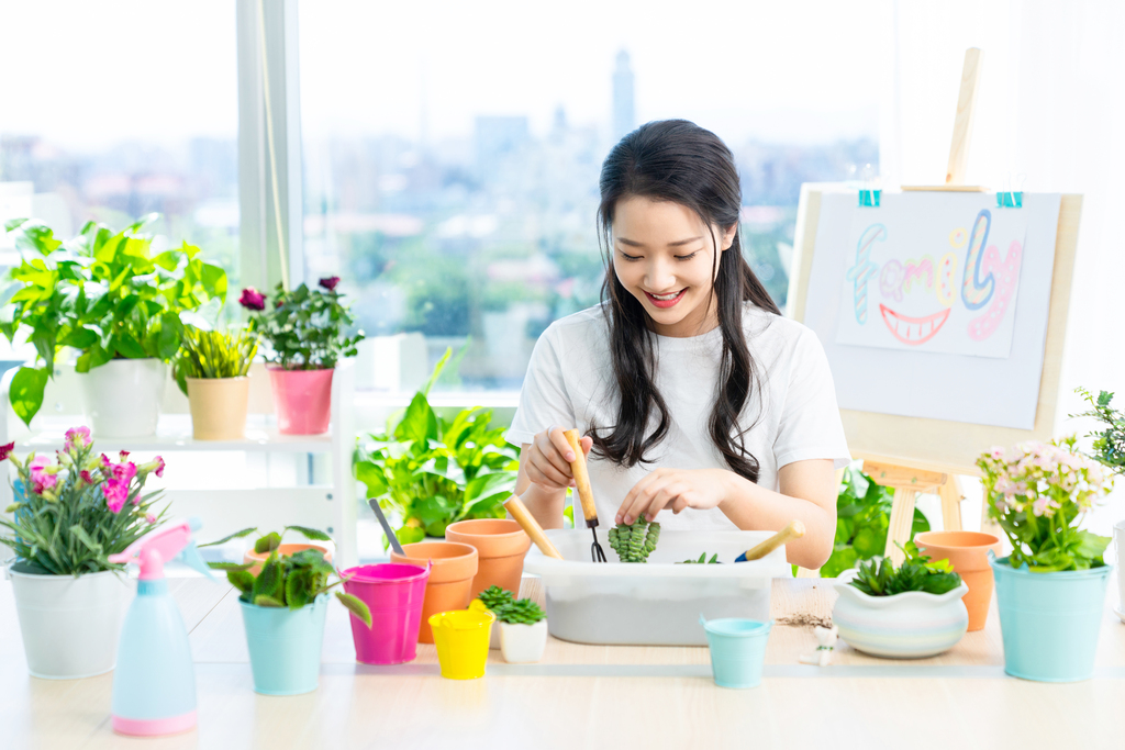 年轻女子在家种植盆栽图片