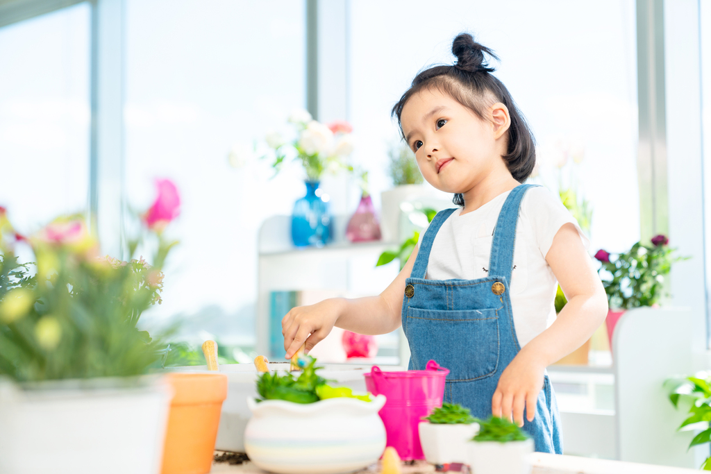 快乐的小女孩在家种植盆栽图片