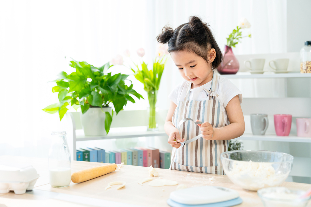 快乐的小女孩在家做饭图片