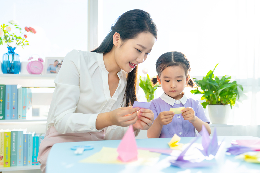 老师和小女孩一起折纸图片