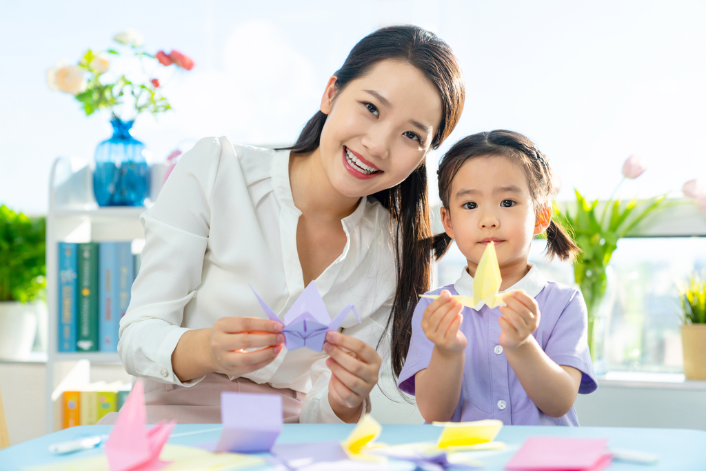 老师和小女孩一起折纸图片