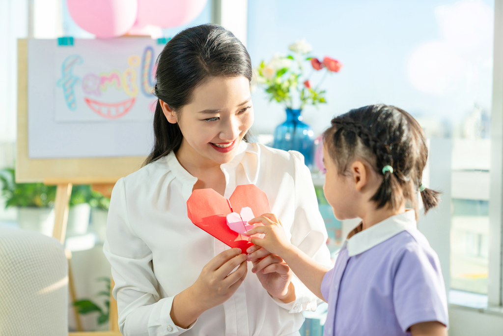 老师和小女孩一起折纸图片