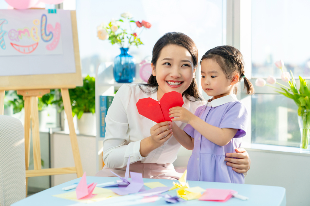 老师和小女孩一起折纸图片