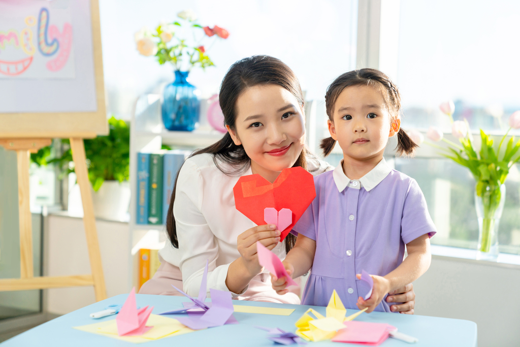 老师和小女孩一起折纸图片