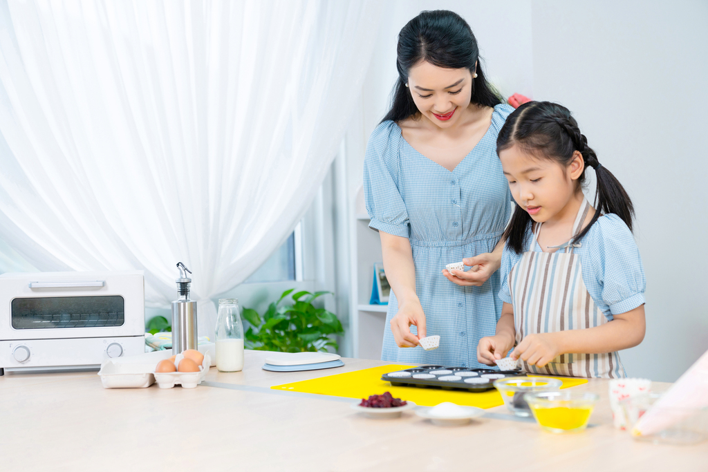 快乐的年轻母女一起制作糕点图片