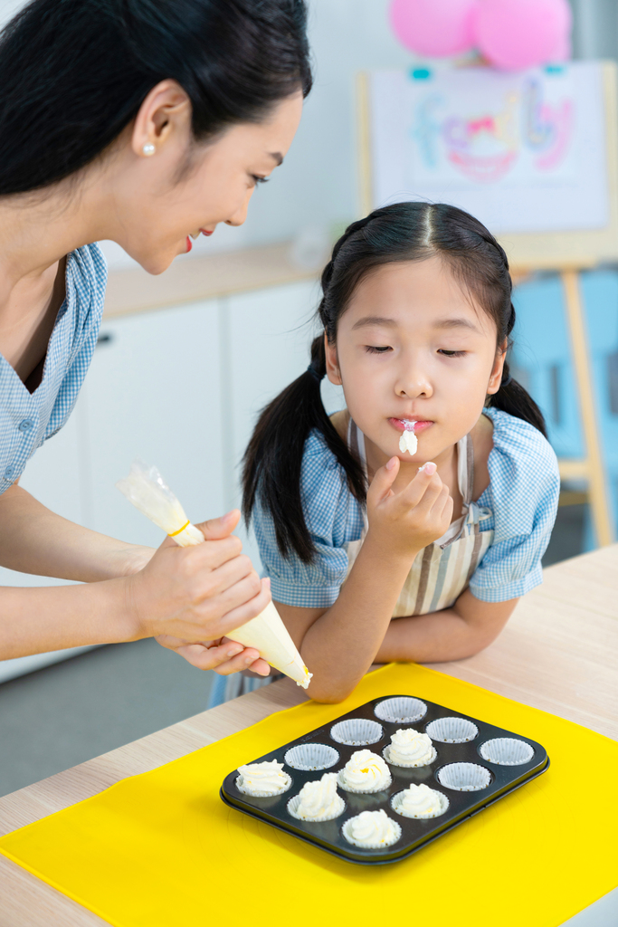 快乐的年轻母女一起制作糕点图片