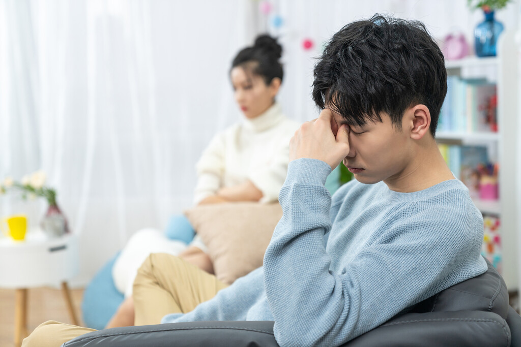 年轻情侣在客厅沙发上争吵图片