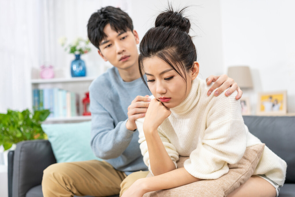 年轻情侣在客厅沙发上争吵
