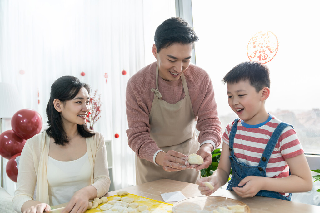 快乐的年轻家庭包饺子图片