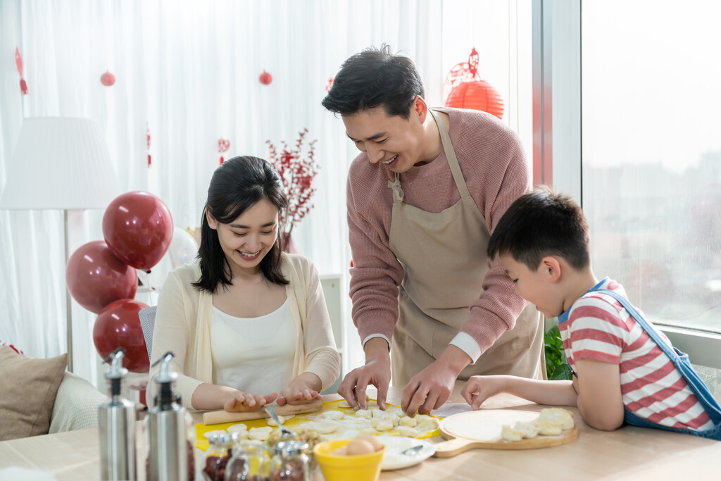 快乐的年轻家庭包饺子图片