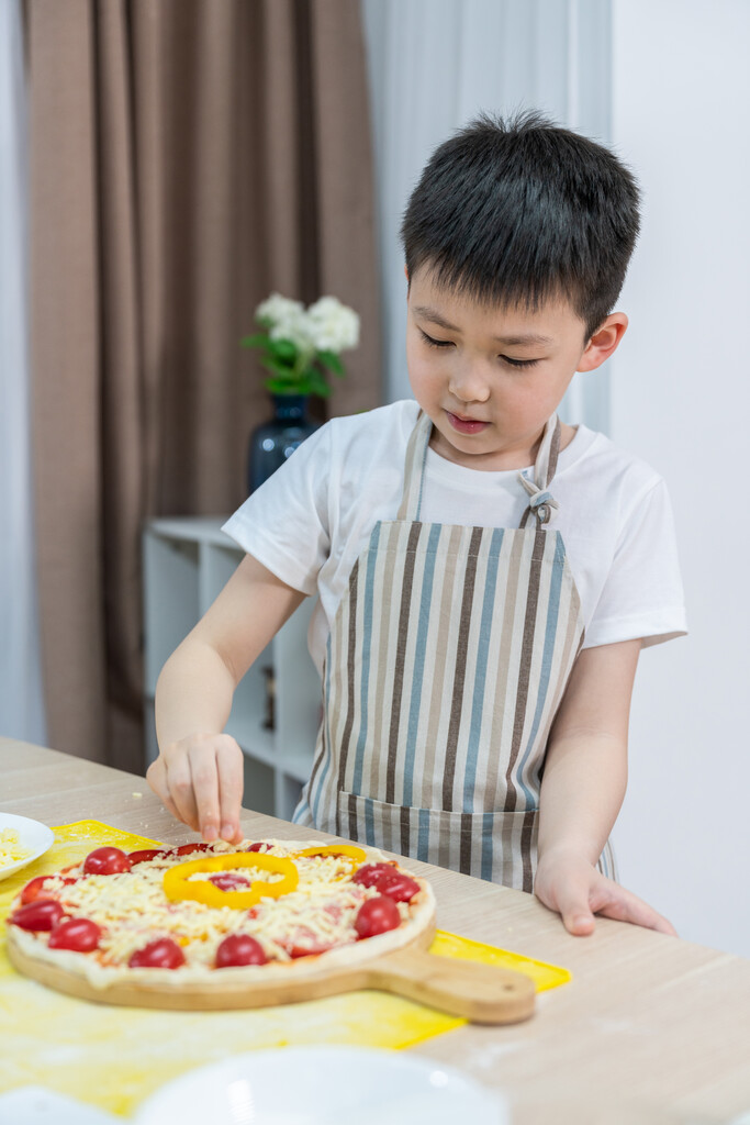 快乐的小男孩做披萨图片