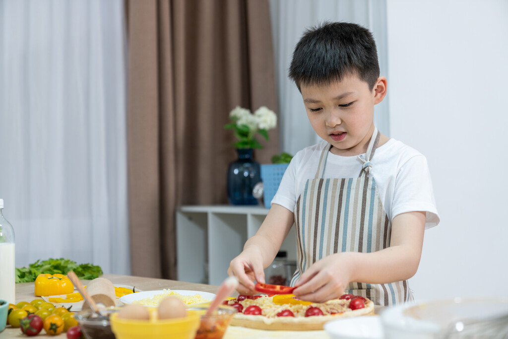 快乐的小男孩做披萨图片