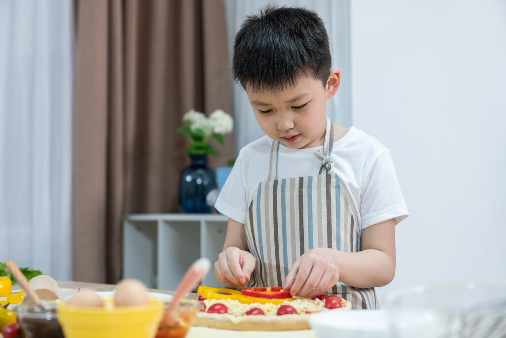 快乐的小男孩做披萨图片