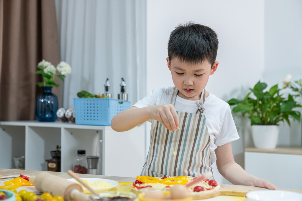 快乐的小男孩做披萨图片