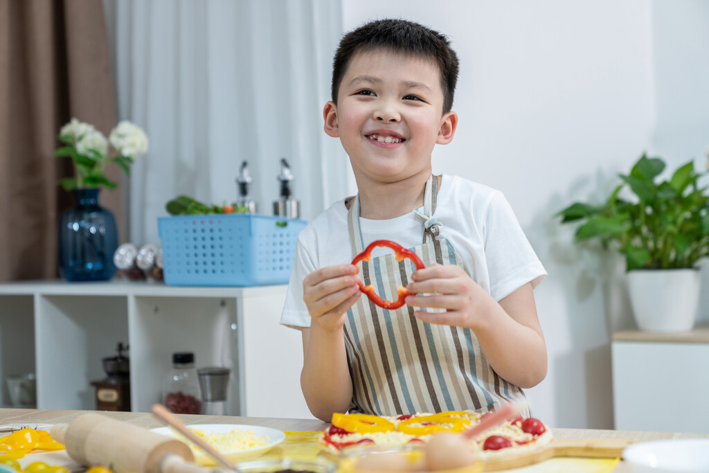 快乐的小男孩做披萨图片