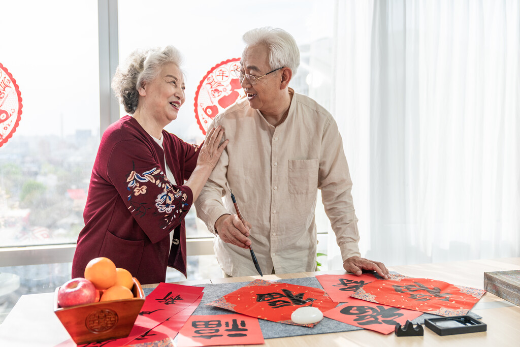 快乐的老年夫妻在家写毛笔字