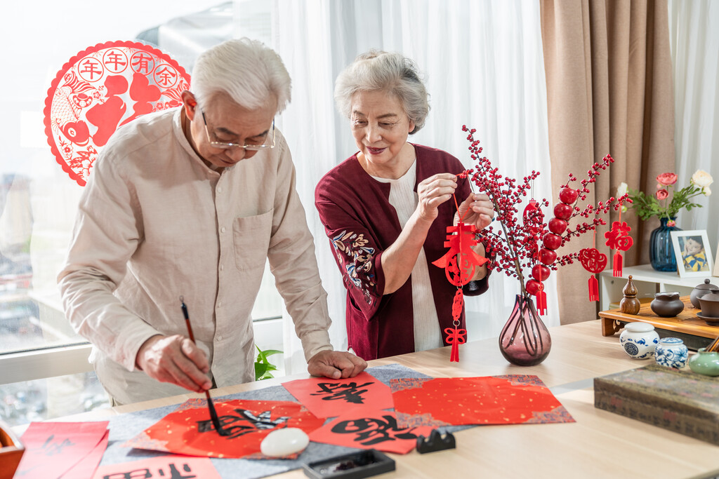 快乐的老年夫妻在家写毛笔字