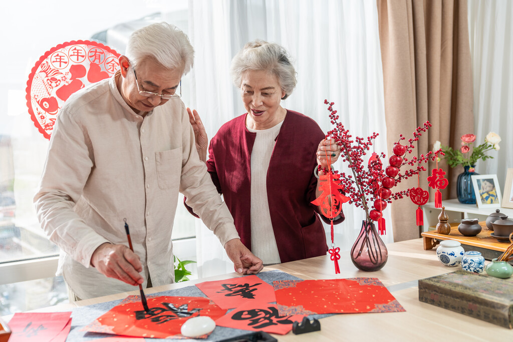 快乐的老年夫妻在家写毛笔字图片