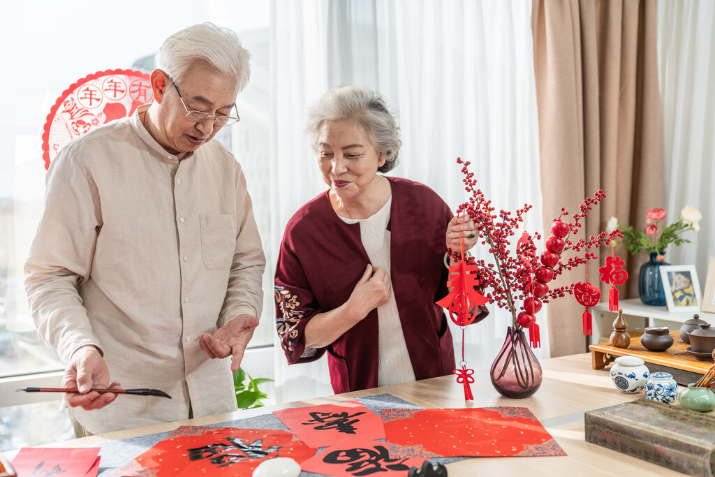 快乐的老年夫妻在家写毛笔字