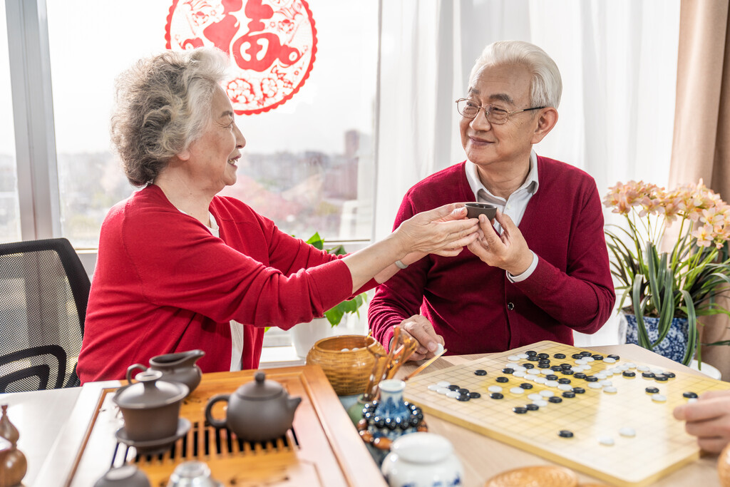 快乐的老年夫妇喝茶下围棋