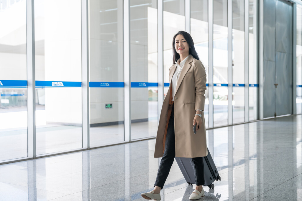 商务女士在机场拉着行李箱图片