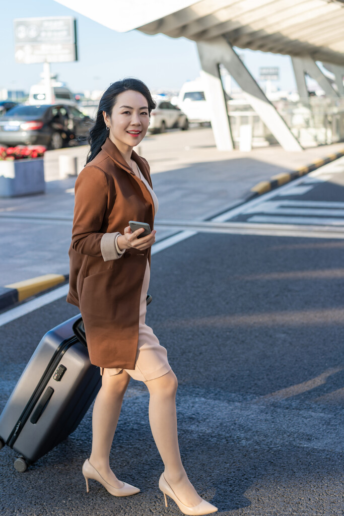 商务女士在机场拉着行李箱图片