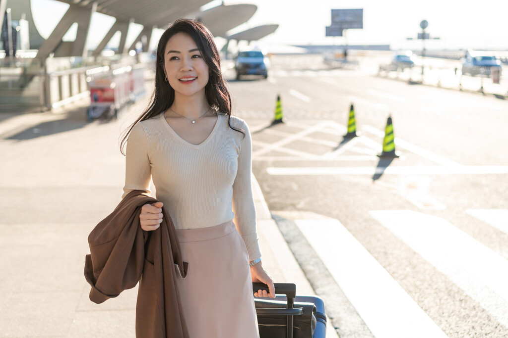 商务女士在机场拉着行李箱图片