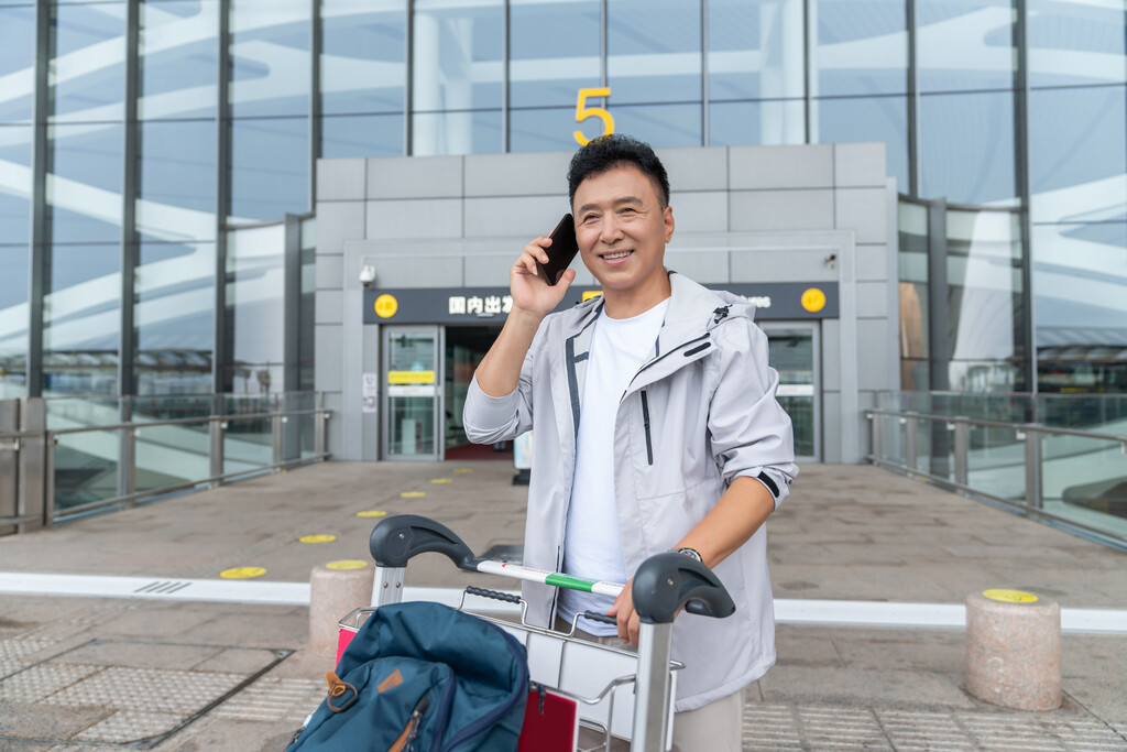 老年男人在机场打电话