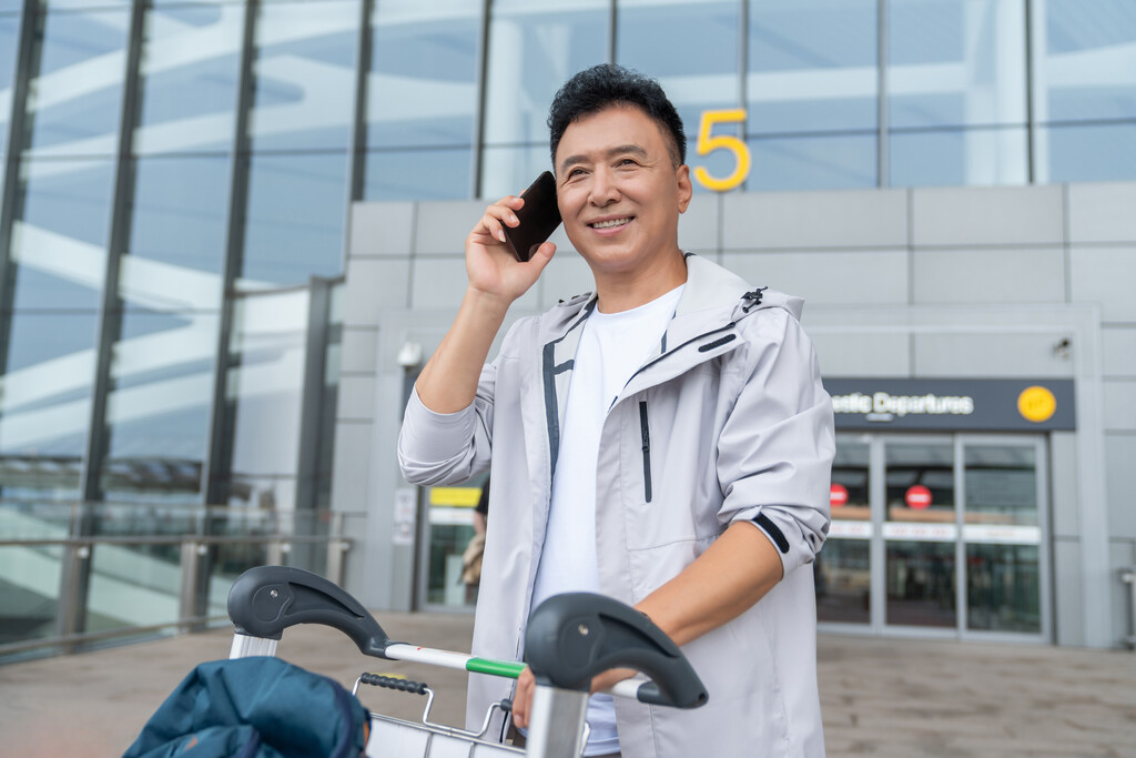 老年男人在机场打电话