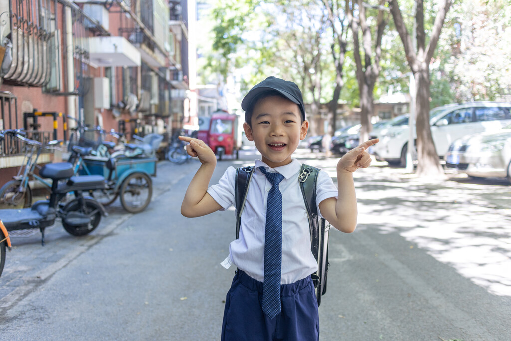 一个背书包穿校服的快乐小学生图片