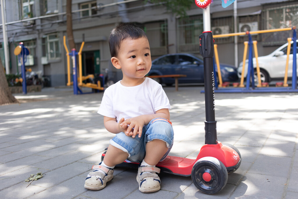 一个小男孩玩滑板车