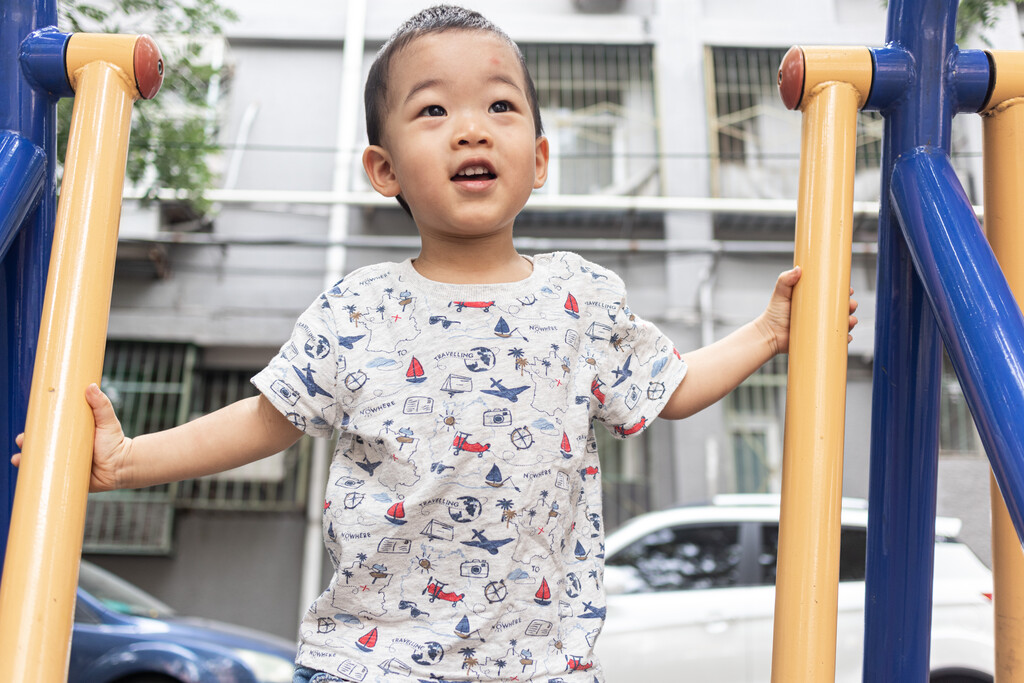 一个小男孩在院子里玩健身器械图片