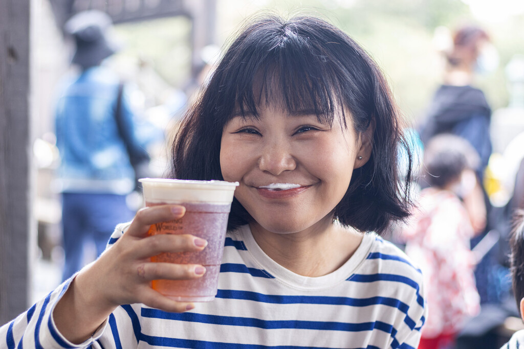 快乐的年轻女人举着一杯啤酒图片